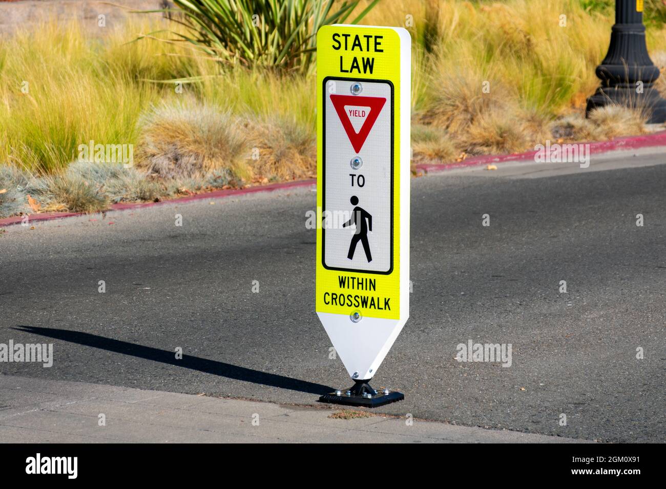 Staatliche Gesetz Rendite für Fußgänger innerhalb Crosswalk reboundable Straßenschild. Stockfoto