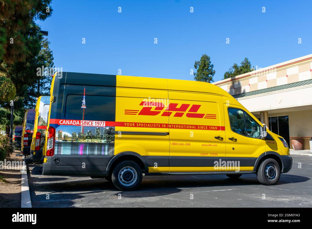 DHL-LKW-Flotte in einem DHL-Service-Center. Die DHL International GmbH ist ein Expresslieferdienst, ein Geschäftsbereich des deutschen Logistikunternehmens De Stockfoto