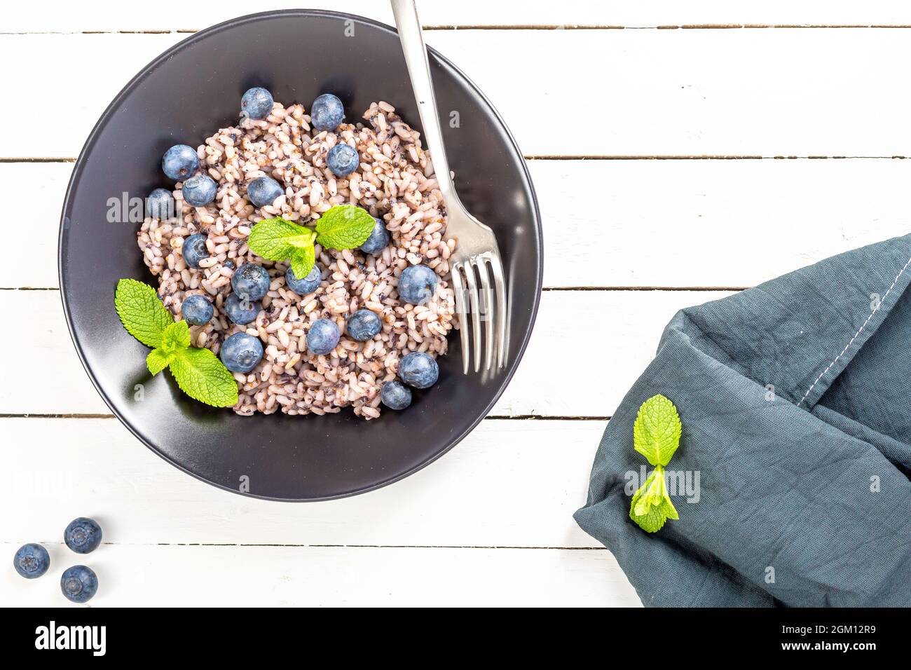 Frische und gesunde vegane Reisschüssel mit Heidelbeerfrüchten serviert. Diät-Konzept. Platz für Ersatzfarben kopieren. Bild für Ihren Food-Blog auf Social Stockfoto