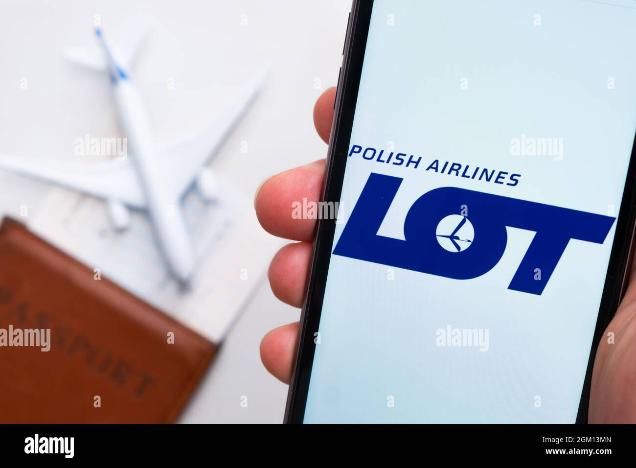 LOT Airline Company App oder Logo auf einem Handy mit Reisepass, Bordkarte und Flugzeug im Hintergrund, September 2021, San Francisco Stockfoto