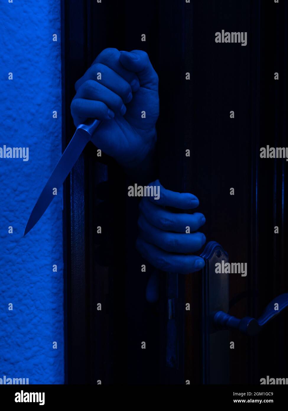 Mann mit einem Messer, der eine Schlafzimmertür öffnete. Halloween und Gewalt Konzept Stockfoto