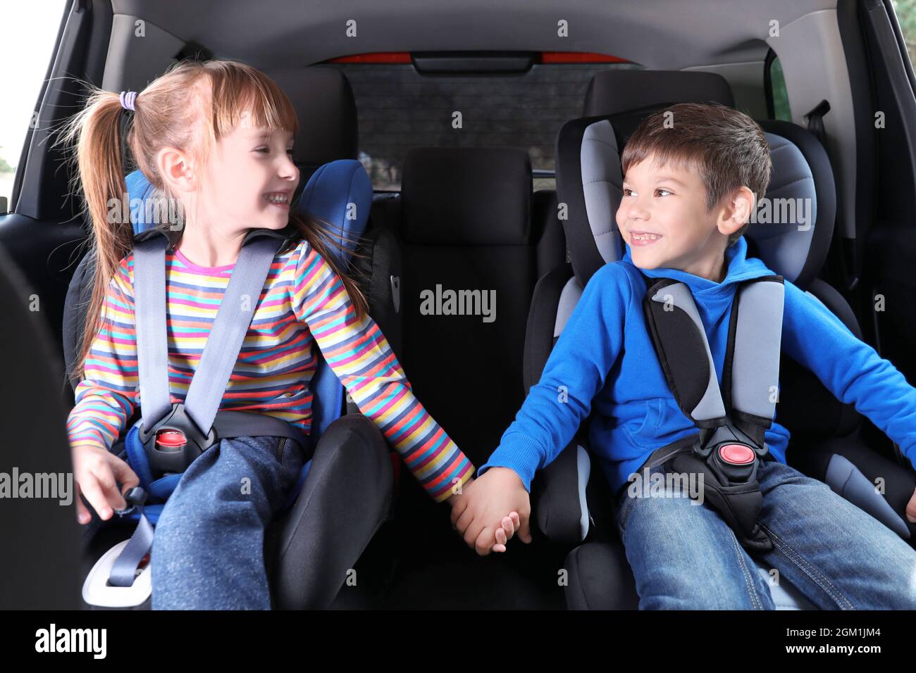 Niedliche Kinder mit befestigt Sicherheitsgurte im Auto Stockfotografie -  Alamy
