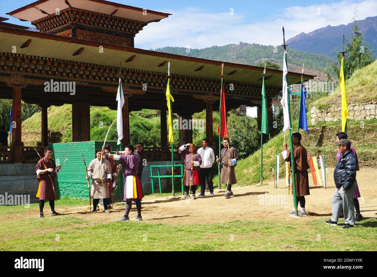 Bhutanische Bogenschützen warten auf ihren Zug, als ein Teammitglied seinen nächsten Schuss in Thimphu, Bhutan, anstellt. Bogenschießen ist der nationale Sport des Königreichs Bhutan. Stockfoto