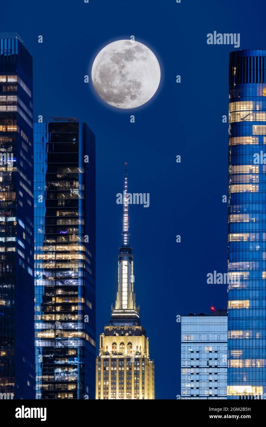 Pink Super-Moon über NYC - die Skyline von New York City leuchtet mit dem Aufstieg des ersten Supermondes von 2021 hinter dem ikonischen Wahrzeichen des Empire auf Stockfoto