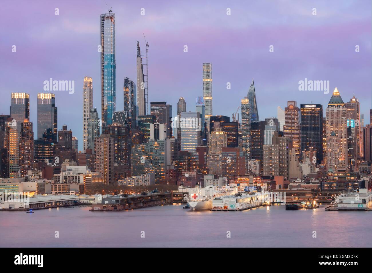 NYC Skyline USNS - Blick auf den USNS Comfort, der am Pier 90 an der Skyline von Midtown Manhattan in New York City, NY, während der Blauen Stunde des Zwielns angedockt ist Stockfoto