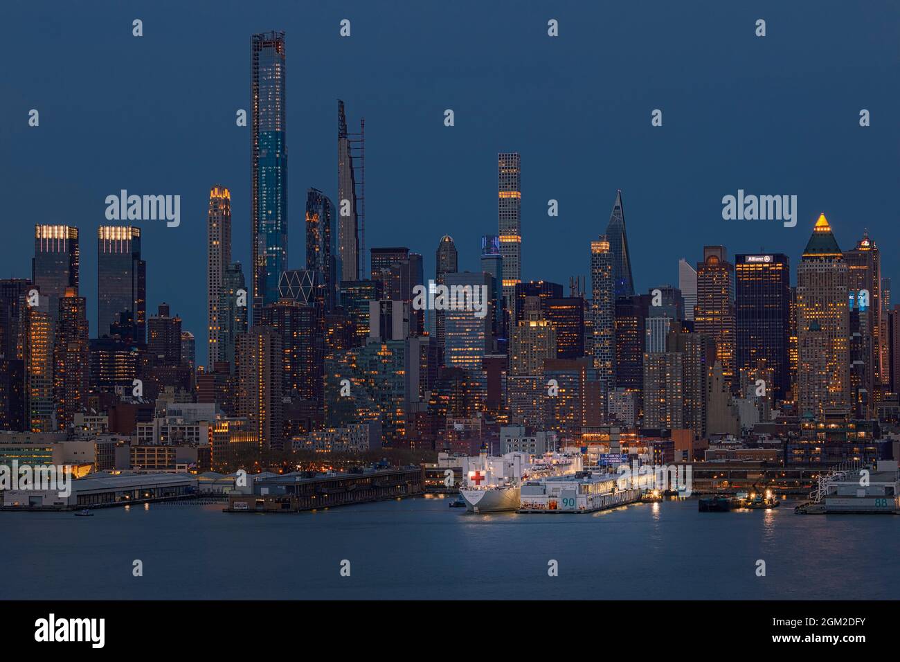 USNS Comfort NYC - Blick auf den USNS Comfort, der am Pier 90 an der Skyline von Midtown Manhattan in New York City, NY, während der Blauen Stunde des Zwielns angedockt ist Stockfoto