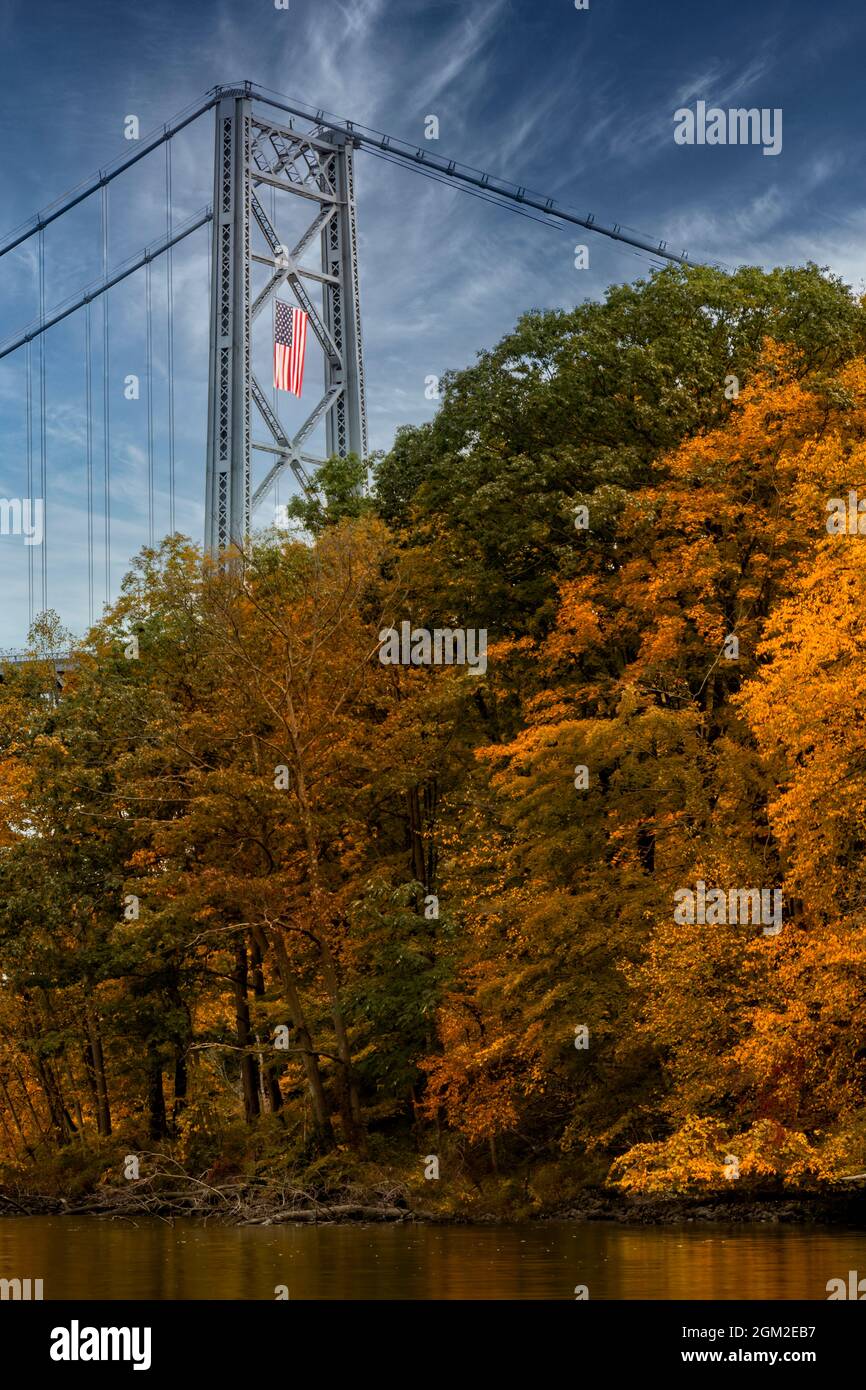 Bear Mountain Bridge Autumn - Blick nach Süden auf die Bear Mountain Bridge, und die Amrican Flagge drapiert über einem der Rungen im Herbst mit seinen m Stockfoto