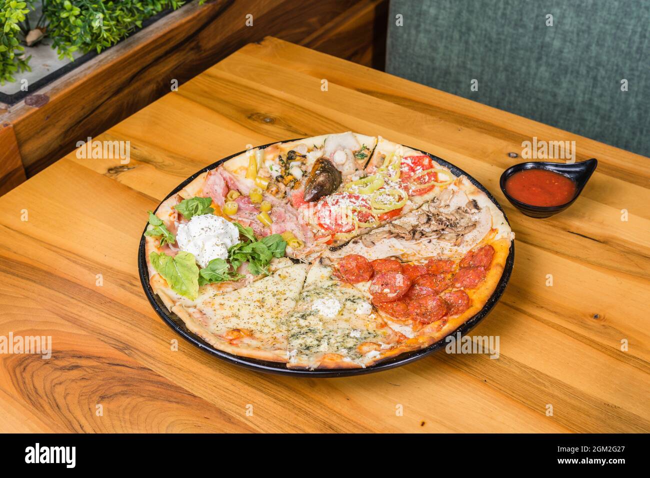 Verschiedene Pizzaarten kombiniert in einem mit Tomatensauce, Brotstäbchen und Pizzabrot Stockfoto