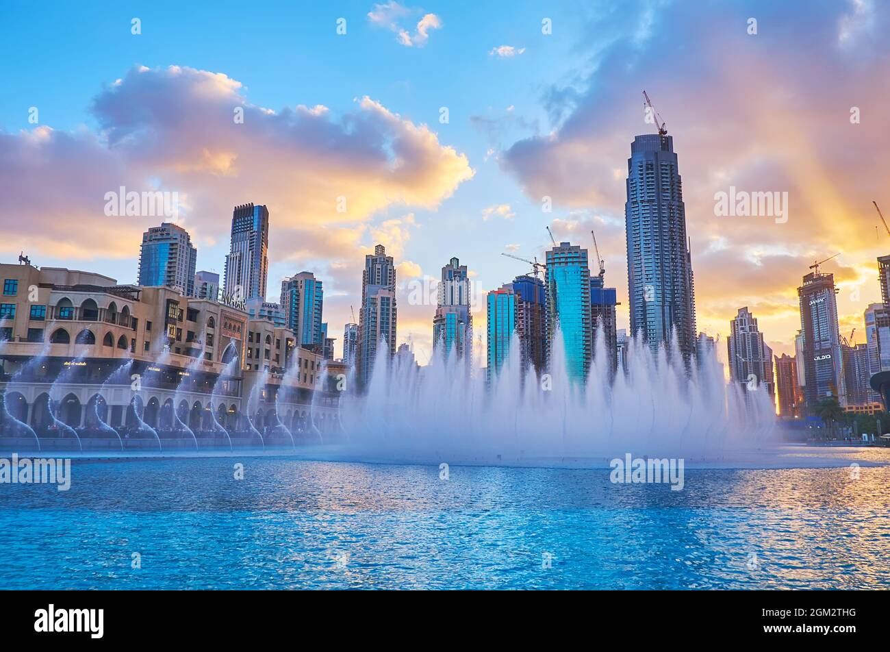 DUBAI, VAE - 7. MÄRZ 2020: Genießen Sie den hellen Sonnenuntergang über den modernen Glashochhäusern und dem Dubai Fountain am 7. März in Dubai Stockfoto