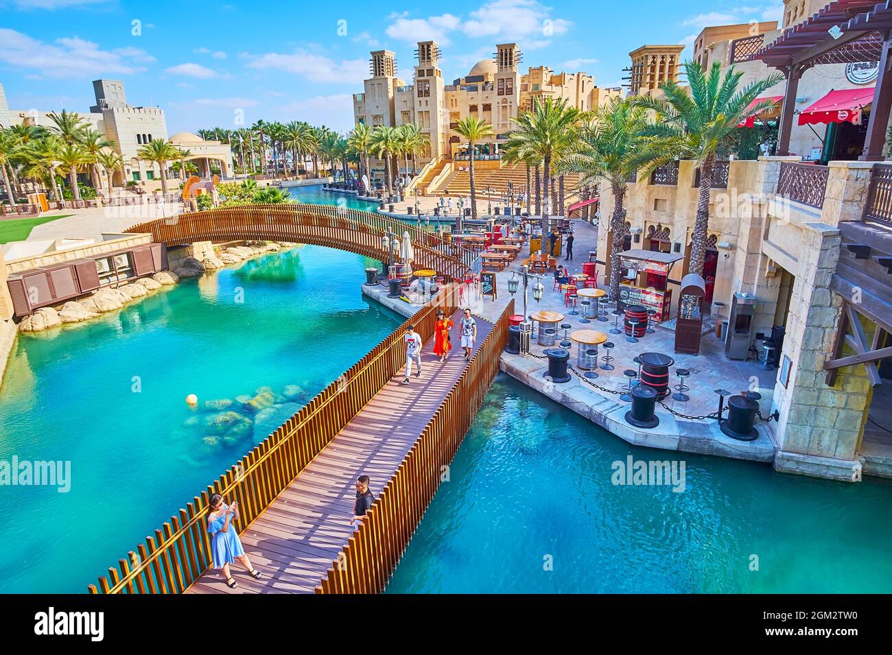 DUBAI, VAE - 4. MÄRZ 2020: Die malerischen Holzstege über die Kanäle und die schönen Restaurants am Ufer des Souk Madinat Jumeirah Market, ON Stockfoto