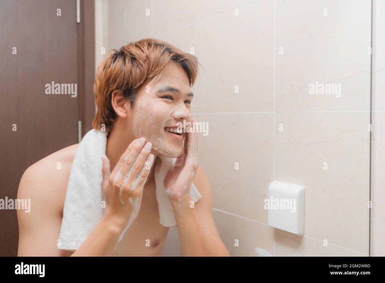 Mann Wasch Gesicht mit Gesichtsreiniger Gesicht Waschseife im Waschbecken im Badezimmer zu Hause. Stockfoto
