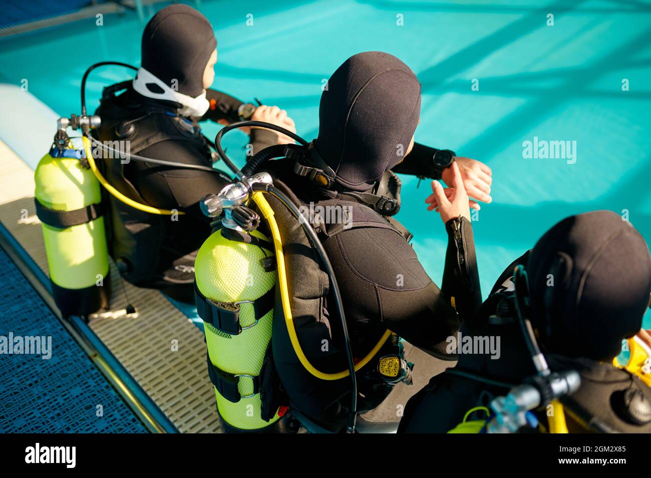 Divemaster und zwei Taucher, die sich auf den Tauchgang vorbereiten Stockfoto