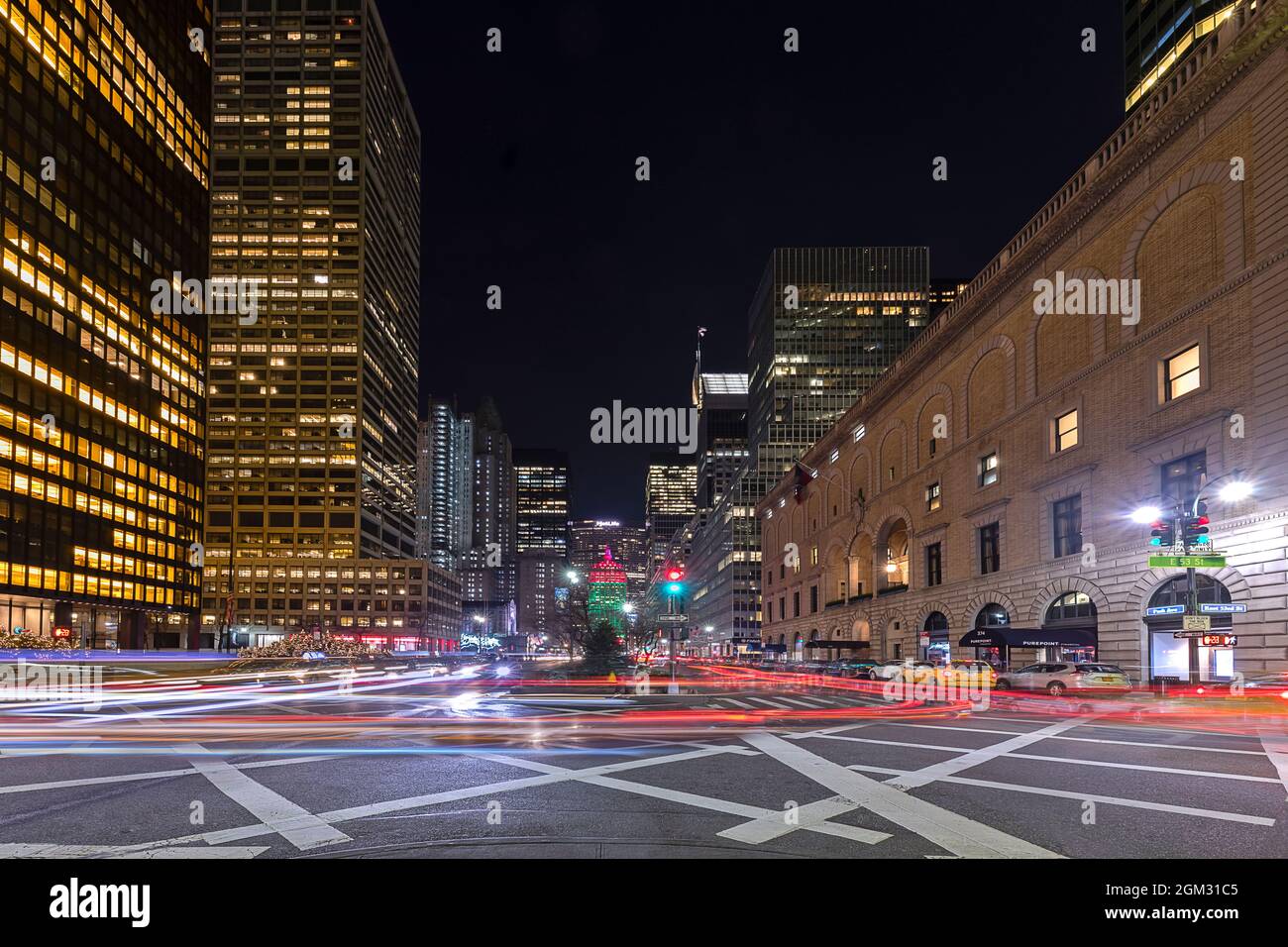 Criss Crossing New York City - der Autoverkehr erzeugt farbenfrohe Lichtstreifen in Midtown Manhattan in NYC. Die Stadt ist in Weihnachtskolo verkleidet Stockfoto