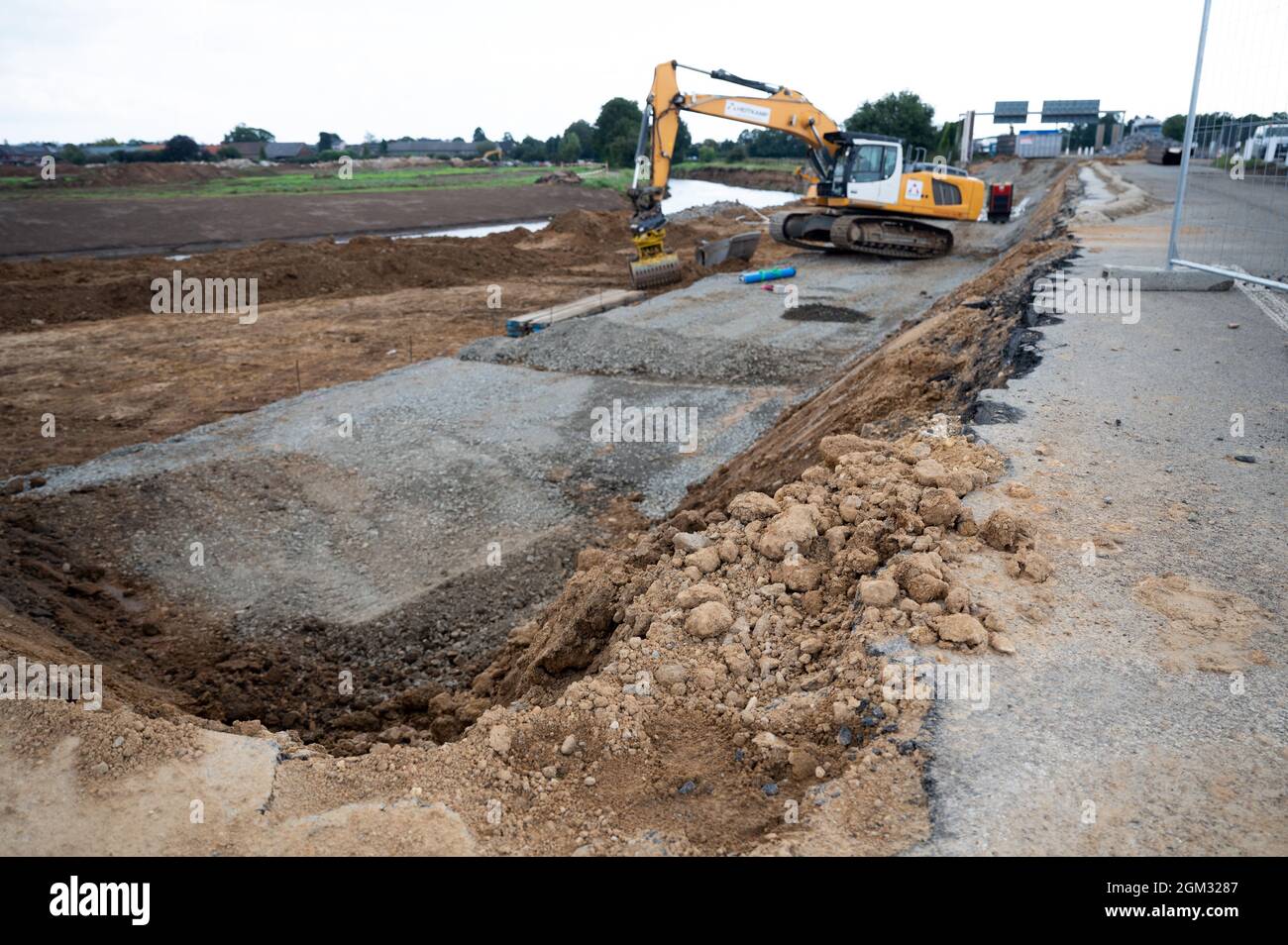 Erftstadt, Deutschland. September 2021. Auf der Autobahn 1 bei Erftstadt arbeiten Baumaschinen, um die weggespülte Straße wieder aufzubauen. Rund 45 Kilometer Autobahn in Nordrhein-Westfalen sind rund zwei Monate nach der Flutkatastrophe noch vollständig gesperrt. Dies betrifft die Autobahnen A 61 zwischen den Kreuzungen Kerpen und Meckenheim sowie die A 1 zwischen den Kreuzungen Erfttal und Hürth, die durch die Überschwemmungen stark beschädigt wurden. Quelle: Federico Gambarini/dpa/Alamy Live News Stockfoto