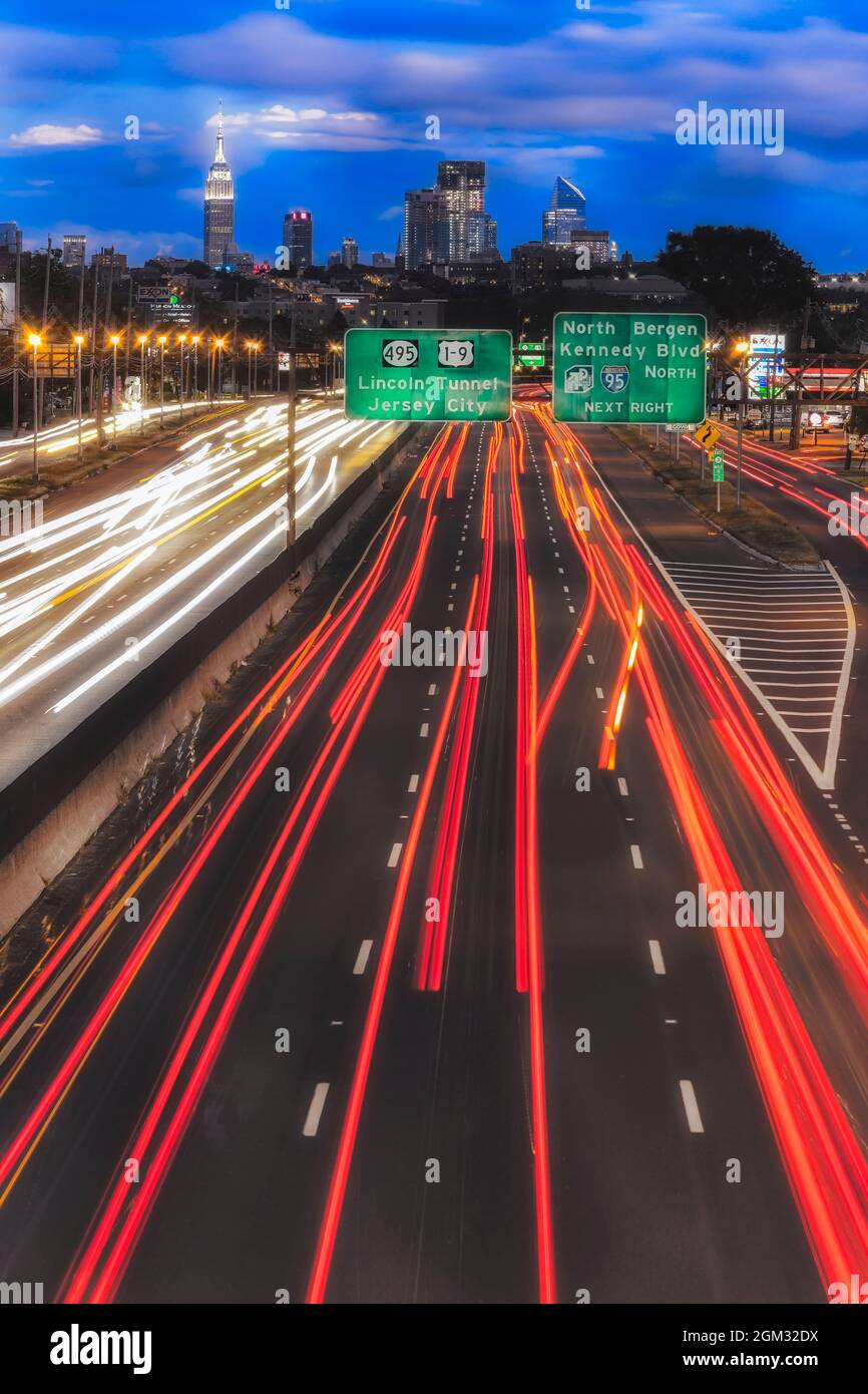 Weg von und nach NYC II - Lichtwege von der Route 3 in New Jersey führen zu einem Blick auf die Skyline von New York City. Präsentiert wird das kultige lan Stockfoto