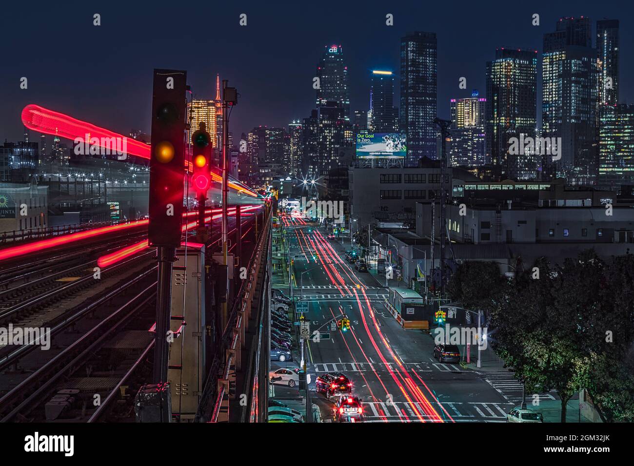 Queens 7 Train und NYC Skyline - Langzeitbelichtung des Flushing, Queens nach Norden mit der Nummer 7 mit Blick auf die Skyline von Manhattan als Hintergrund. Stockfoto