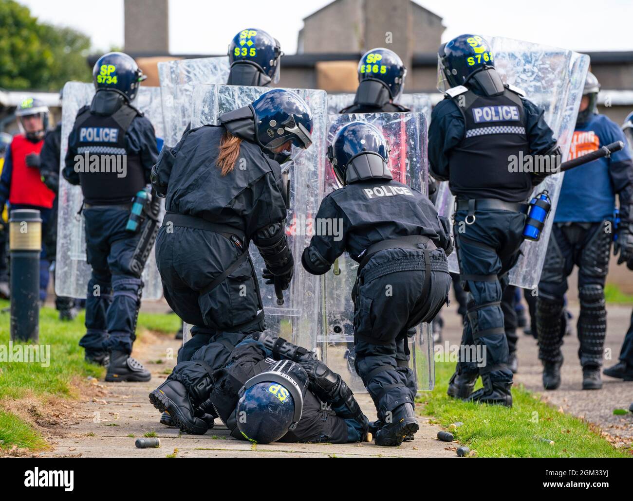 South Queensferry, Schottland, Großbritannien. September 2021. Die Polizei in Schottland lädt die Presse ein, ihre laufenden öffentlichen Ordnungsschulungen im Craigiehall Camp in South Queensferry miterleben zu dürfen. Das Training soll die Polizei auf die bevorstehende COP26-Veranstaltung im November in Glasgow vorbereiten, bei der Proteste erwartet werden. Die Polizei stand in Bereitschaftsspiel gegen die Polizei, die die Rolle der Demonstranten einnahm, die Raketen warfen und sie mit Schlägern Angriffen. PIC; verletzter Polizist, der von Kollegen geschützt wird. Iain Masterton/Alamy Live News. Stockfoto