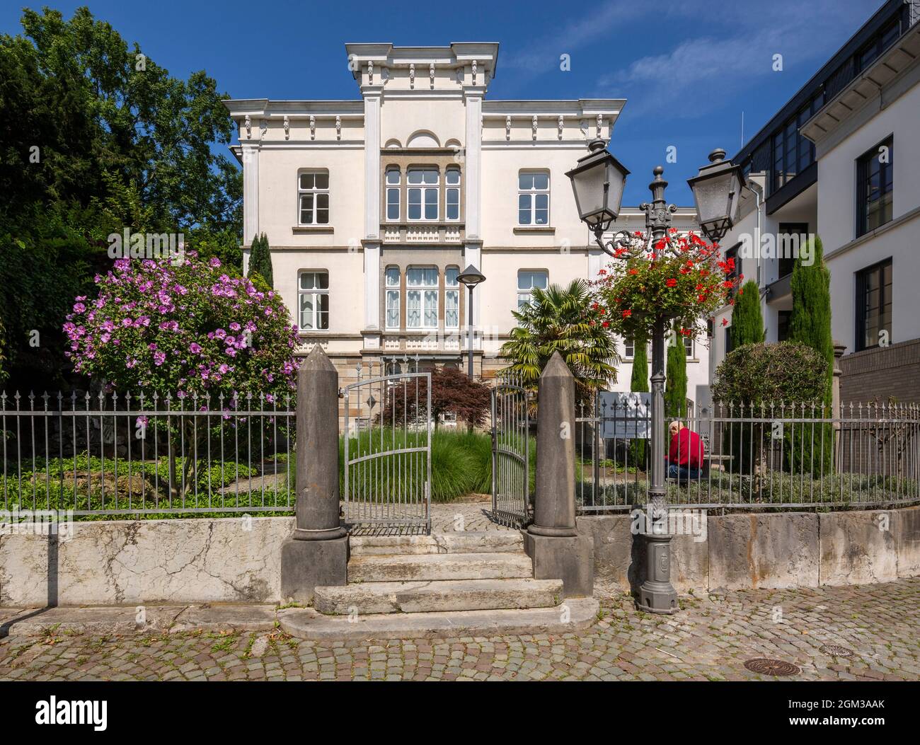 Deutschland, Mettmann, Bergisches Land, Niederbergisches Land, Niederberg, Rheinland, Nordrhein-Westfalen, NRW, Villa Beckershoff, benannt nach Johann Wilhelm Beckershoff, ehemaligem Bauunternehmer und Steinbruchbesitzer in Mettmann, Klassizismus, Kulturvilla, blühende Büsche, Fenceline, Eingangstor, Straßenlampe, Laterne Stockfoto