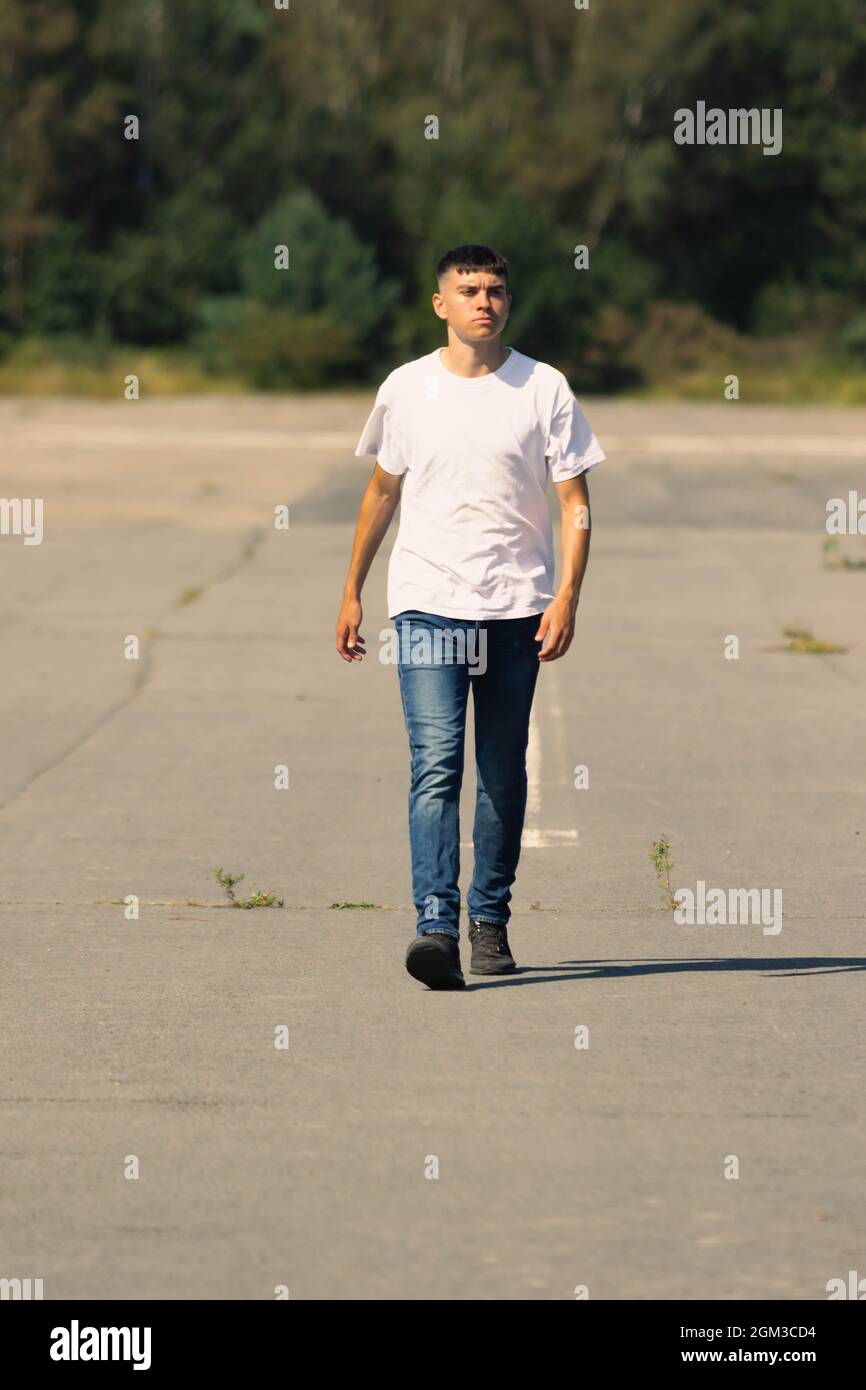 18-jähriger Teenager-Junge in einem weißen T-Shirt im Freien und einer  blauen Denim-Jeans Stockfotografie - Alamy