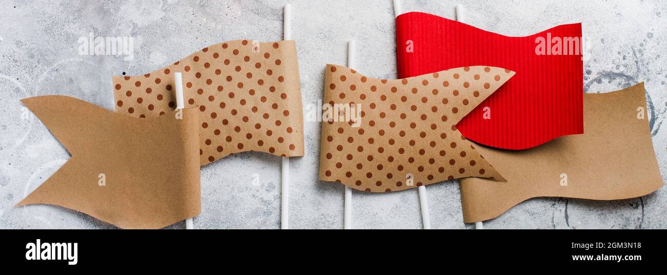 Dekorative Flaggen aus Bastelpapier auf grauem, altem Betonhintergrund. Draufsicht. Banner. Stockfoto