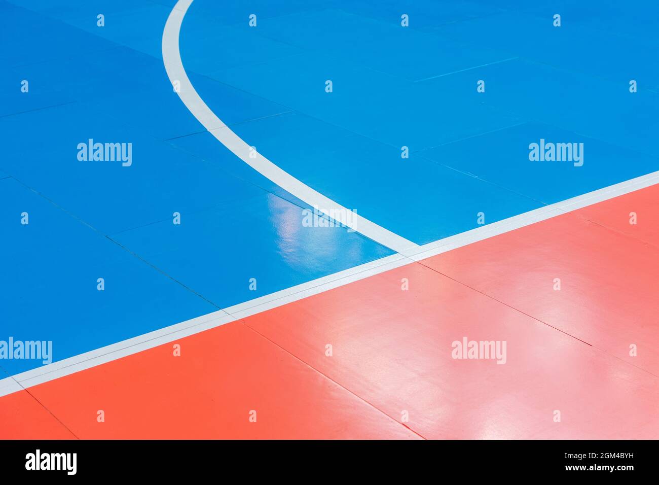 Volleyball, Basketball, Badminton, Futsal, Handballplatz in Blau und Orange. Holzboden der Sporthalle mit Markierungslinien Linie auf Holzboden i Stockfoto
