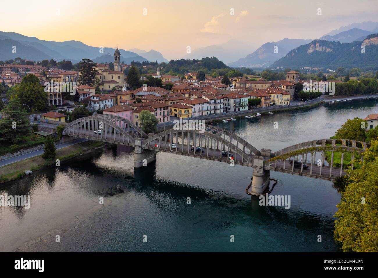 Drone Panoramablick über Brücke und Fluss in Richtung eines charakteristischen italienischen Dorf, Brivio, Lombardei, Italien Stockfoto