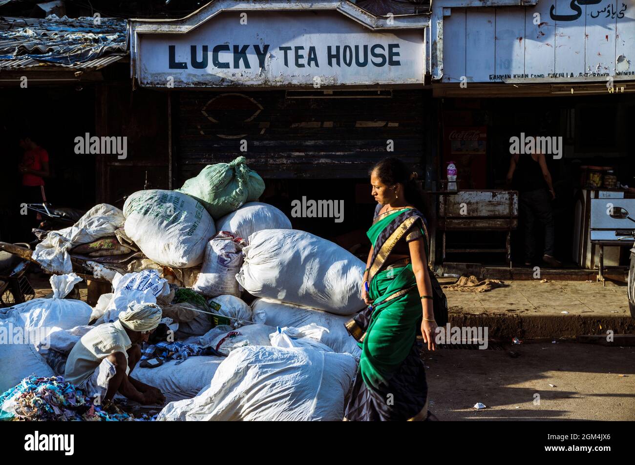 Mumbai, Maharashtra, Indien: Eine Frau geht an einem alten Teehaus vorbei. Stockfoto