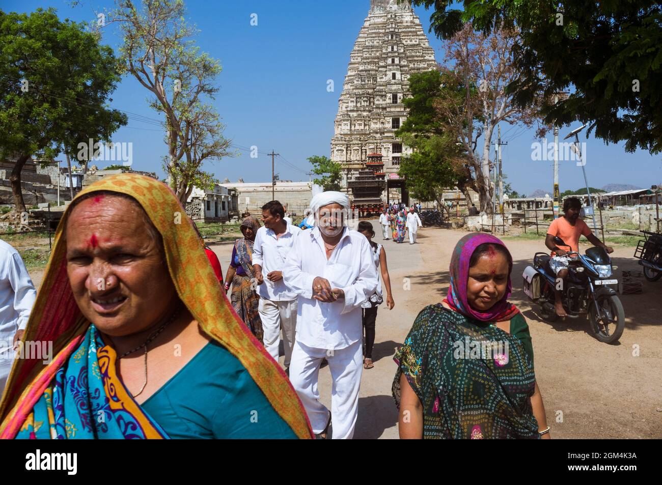 Hampi, Karnataka, Indien: Menschen gehen außerhalb des Sree Virupaksha Tempels aus dem 7. Jahrhundert. Es wird angenommen, dass es seit seiner Gründung ununterbrochen funktioniert Stockfoto