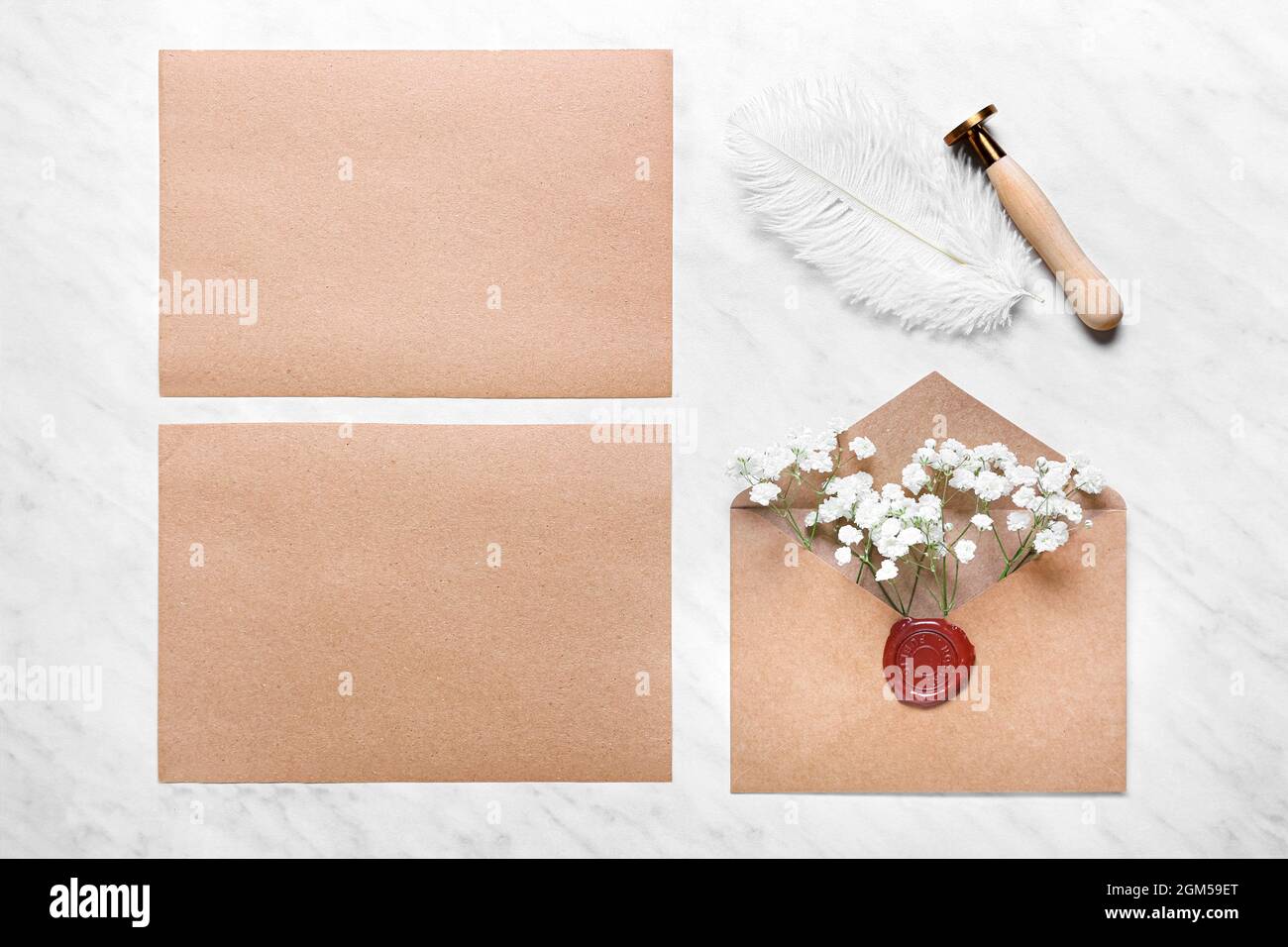 Leere Karten mit Umschlag, Blumen und Stempel auf weißem Hintergrund Stockfoto
