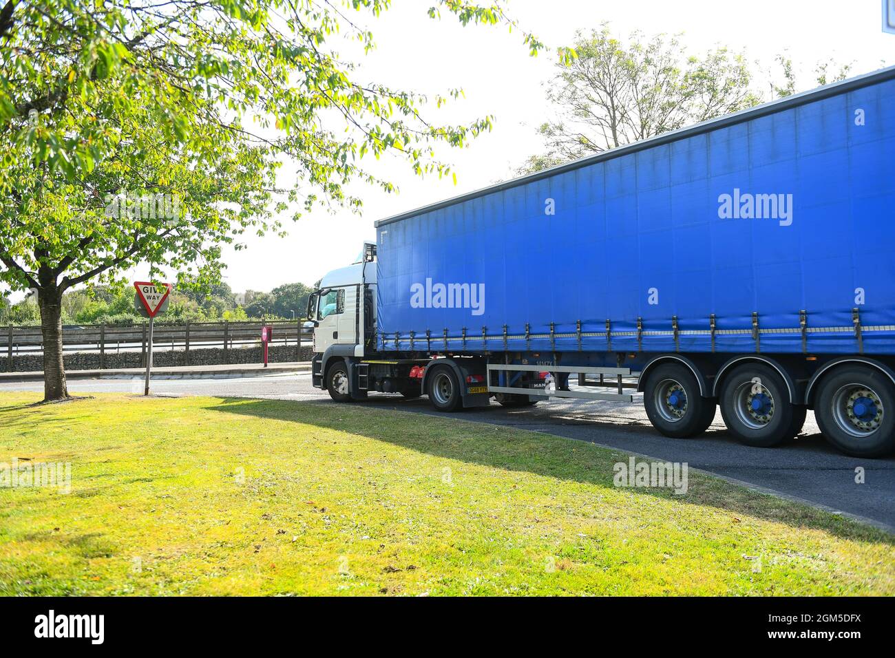 Ein Containerwagen verlässt die M27-Tankstelle Rownhams in der Nähe von Southampton England, um die Fahrt auf der Autobahn M27 zu fortsetzen. Stockfoto