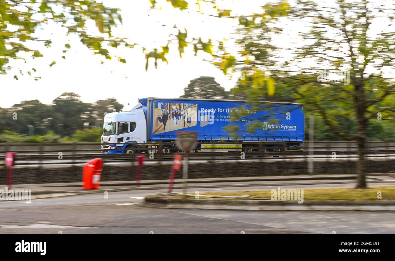 Eine Drehaufnahme eines Lastwagen, der sich um britische Gips kümmert, die auf der M27 in der Nähe von Southampton England fahren. LKW-Fahrer sind gefragt und das Angebot ist knapp. Stockfoto