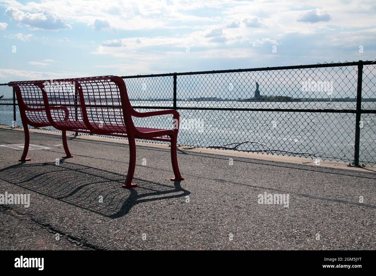 Die rote Bank mit Blick auf Lady Liberty von Governor Island in New York City Stockfoto