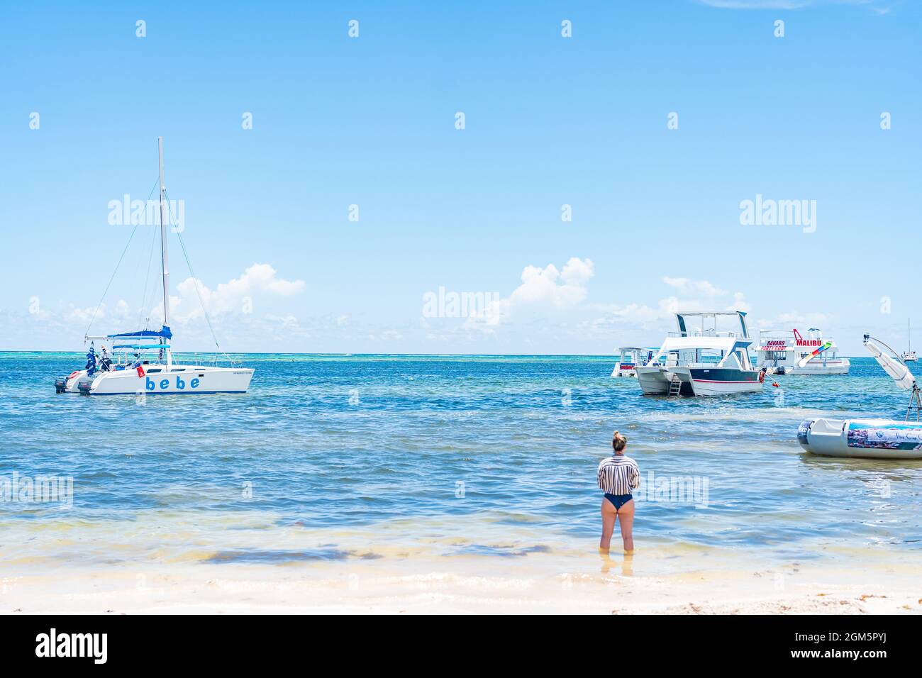 Touristen genießen den unberührten Strand von Tourist Party Boats in der Dominikanischen Republik umgeben. Stockfoto