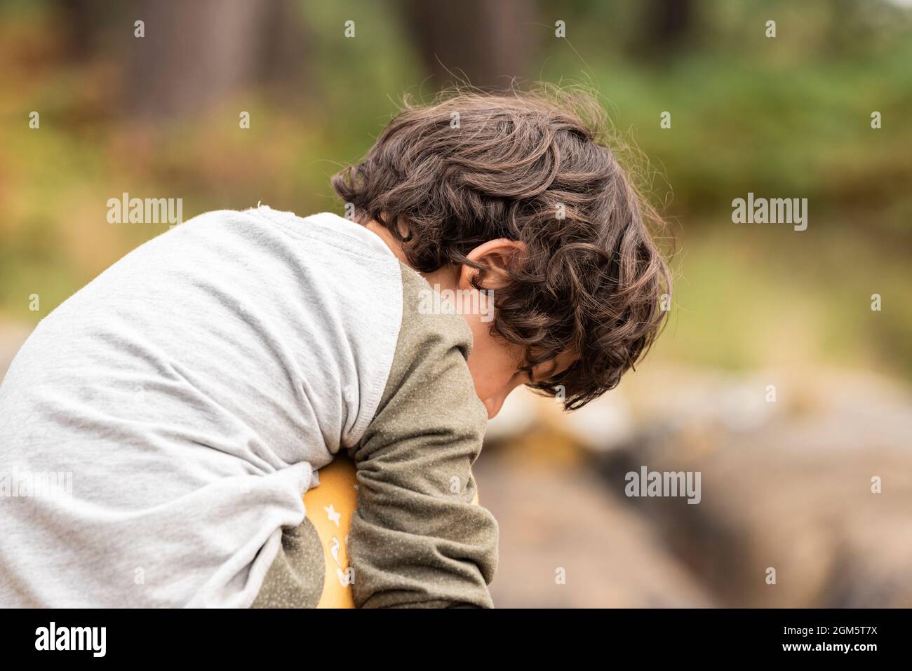 Portrait während der Reise von weißen kaukasischen Mädchen mit kurzen Haaren. Mit Klippe und Wald im Hintergrund. Stockfoto