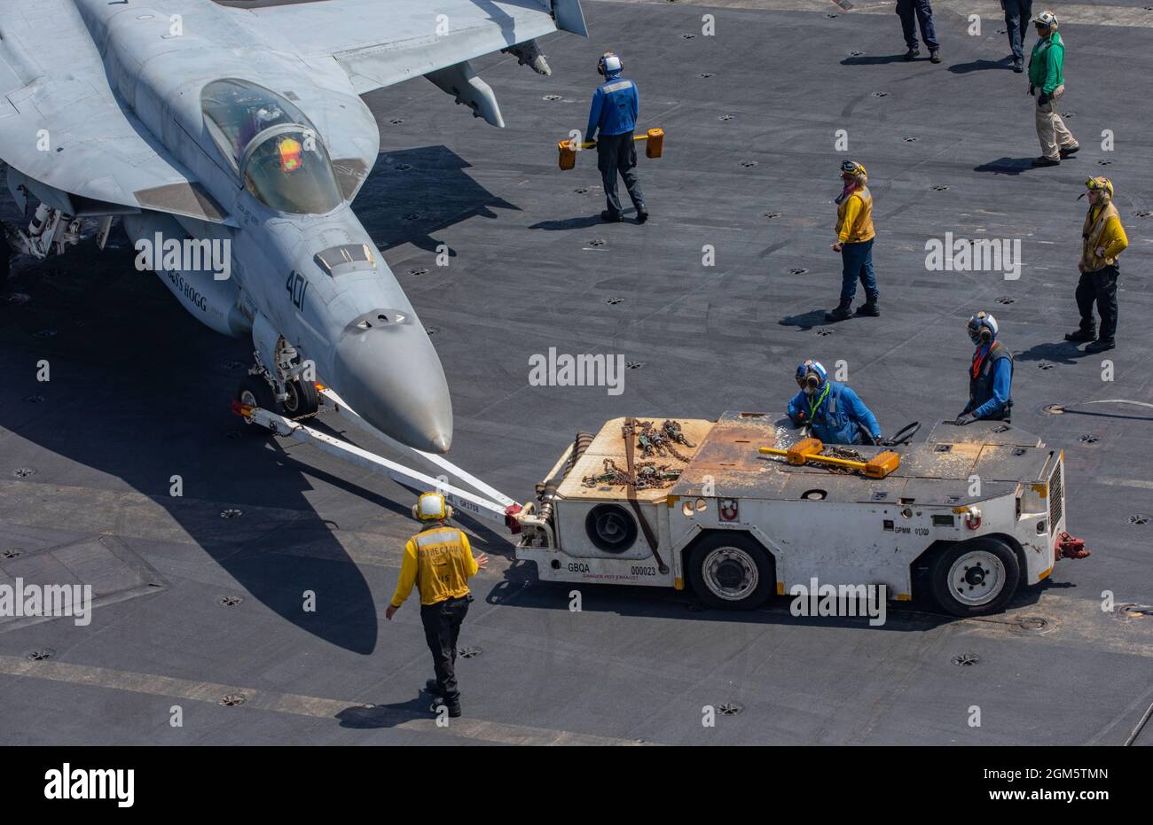 Arabian Sea, Vereinigte Staaten. 13. September 2021. Die Matrosen der US-Marine schleppen einen F/A-18E Super Hornet Kampfjet, der an den Dambusters of Strike Fighter Squadron 195 befestigt ist, vor dem Flugbetrieb auf dem Flugzeugträger USS Ronald Reagan der Nimitz-Klasse während einer Routinepatrouille als Flaggschiff der 5. Flotte am 13. September 2021 im Arabischen Meer. Kredit: MC3 Santiago Navarro/Planetpix/Alamy Live Nachrichten Stockfoto