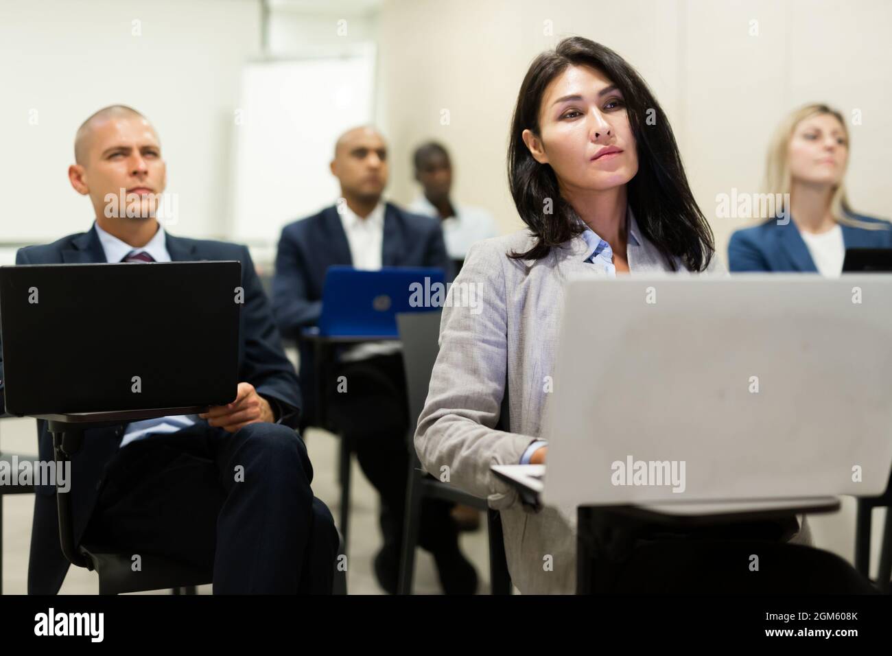 Asiatische Geschäftsfrau, die während eines Unternehmensseminars an einem Laptop arbeitet Stockfoto