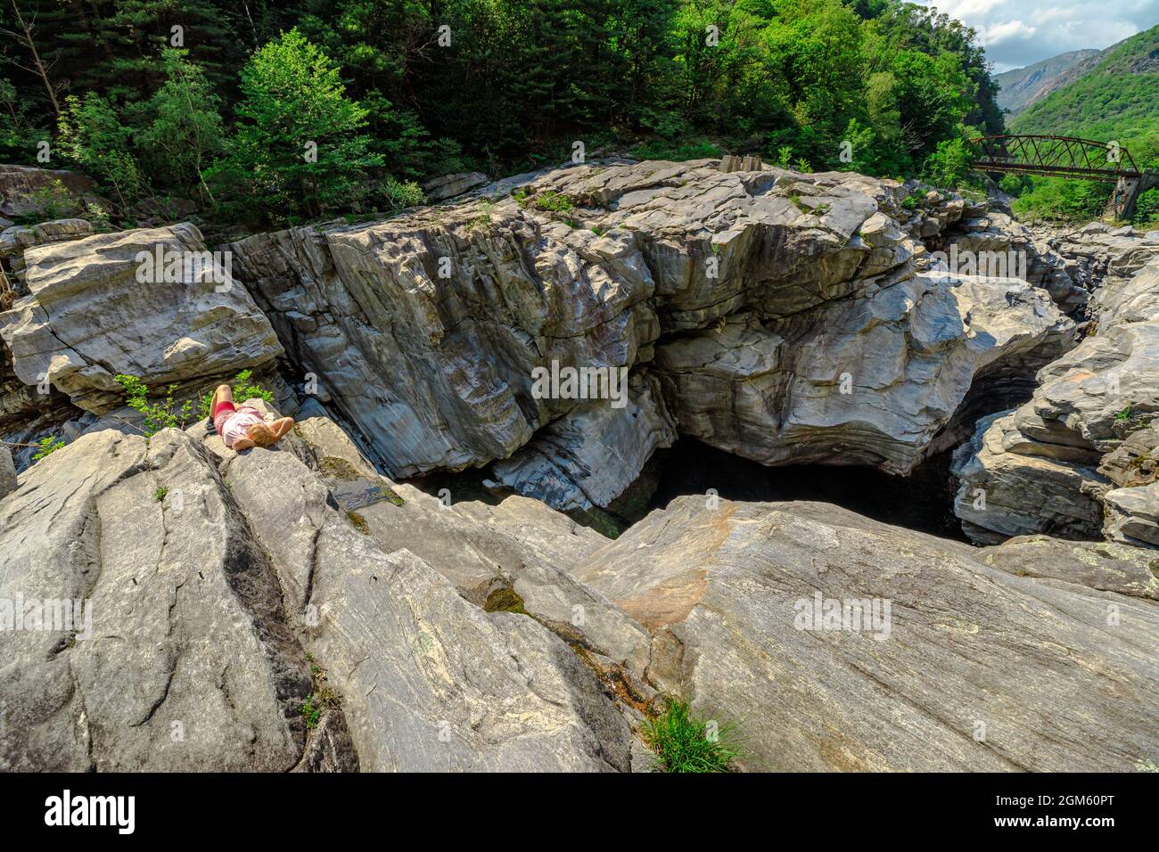 Frau zwischen Schluchten der Schlucht des Aussichtspunkts Ponte Brolla Brücke im Tessin Schweiz. Ponte Brolla ist eine berühmte Attraktion, wo Sie sich sonnen können Stockfoto