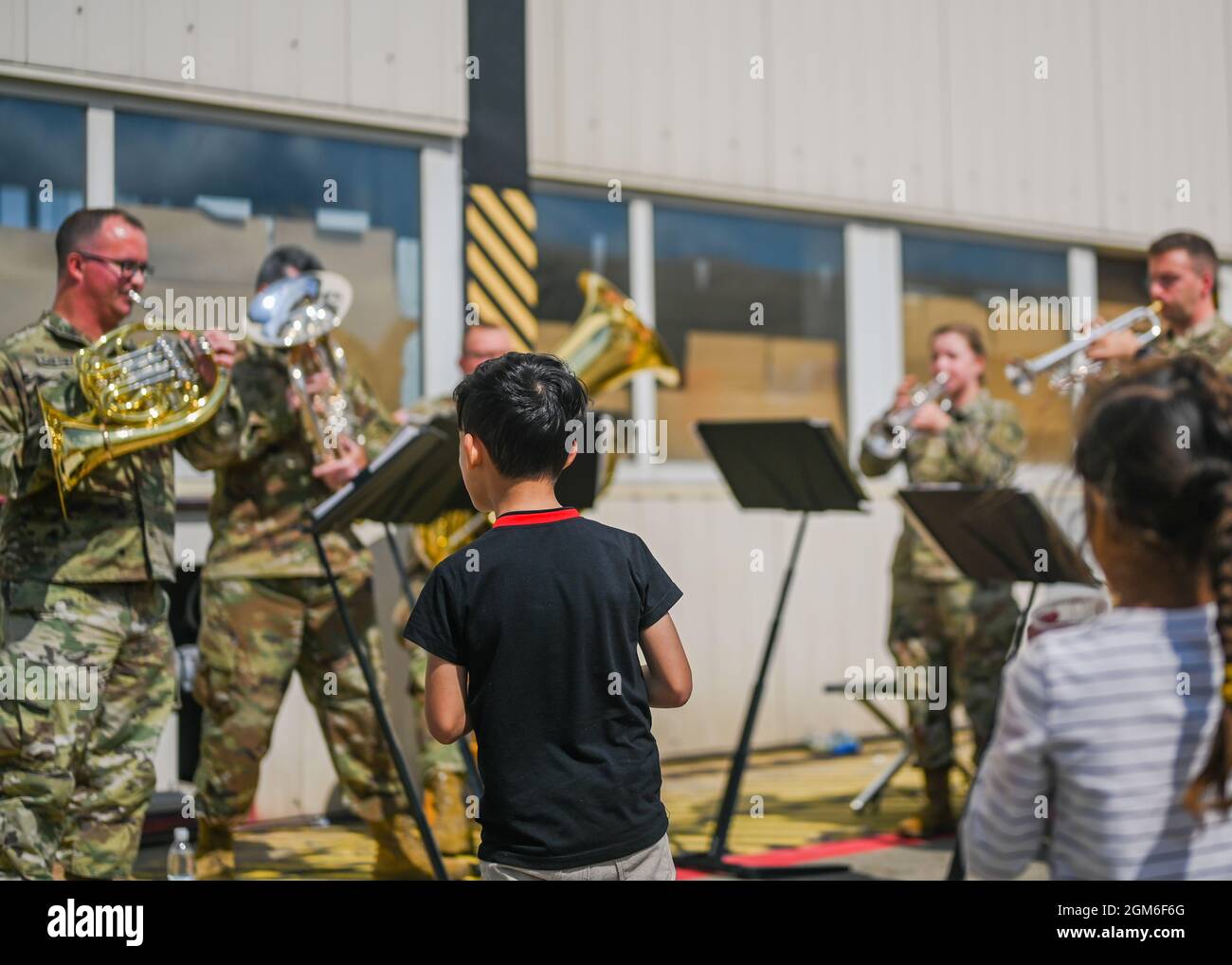 US Army Europe and Africa Band und Chorus Musiker treten für Evakuierte auf dem Ramstein Air Base, Deutschland, am 24. August 2021 auf. Die USAEUR- AF Band & Chorus spielten verschiedene Songs für Hunderte von Evakuierten, während sie sich für die Weiterbewegung an ihren endgültigen Bestimmungsort vorstellten. (USA Luftwaffe Foto von Senior Airman Jan K. Valle) Stockfoto