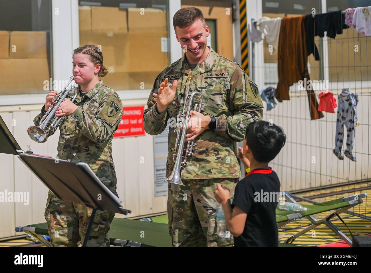 Sergeant Robert Chambers, EU-Seiltruppen der US-Armee und Musiker der Africa Band und des Chorus winkt bei einem Kind auf dem Ramstein Air Base, Deutschland, 24. August 2021. Die USAEUR AF Band & Chorus unterstützten die Operations Allies Refuge, indem sie den Evakuierten Unterhaltung zur Verfügung stellten, während sie sich in einer temporären Unterkunft auf dem Ramstein Air Base befinden. (USA Luftwaffe Foto von Senior Airman Jan K. Valle) Stockfoto