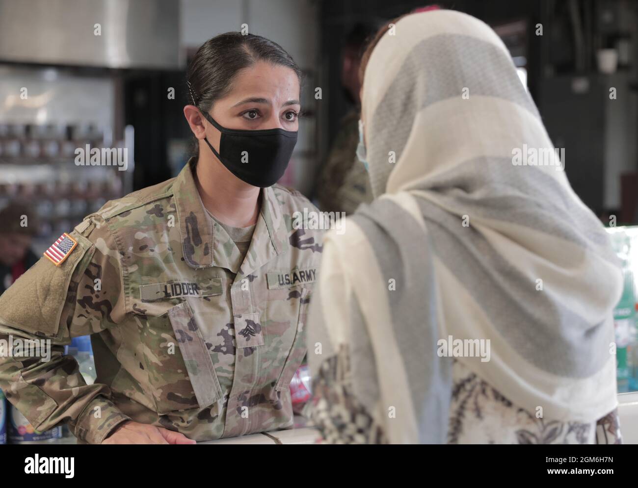 Sgt. Simranjeet Lidder, ein Übersetzer, der der 1. Brigade, 1. Panzerdivision, zugewiesen wurde, hilft Freiwilligen des amerikanischen Roten Kreuzes, Vorräte zu übergeben, indem sie am 9. September 2021 übersetzen, was die afghanischen Evakuierten benötigen. Das Verteidigungsministerium stellt über das Northern Command der USA und zur Unterstützung des Heimatschutzministeriums so schnell wie möglich Transport, vorübergehende Unterbringung, medizinische Vorsorgeuntersuchungen und allgemeine Unterstützung für mindestens 50,000 afghanische Evakuierte in geeigneten Einrichtungen, in permanenten oder temporären Strukturen bereit. Diese Initiative bietet afghanischen Mitarbeitern eine wesentliche Unterstützung bei Secure loc Stockfoto