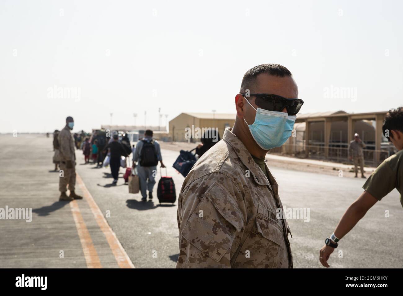 U.S. Marine Corps Lance CPL. Mauricio Tinoco mit dem Evakuierungskontrollzentrum führt afghanische Evakuierte zum Flugzeug auf der Al Udeid Air Base, Katar, 3. September 2021. Das Verteidigungsministerium hat sich verpflichtet, die Evakuierung amerikanischer Bürger, Visa für Sondereinwanderer und anderer gefährdete Personen aus Afghanistan zu unterstützen. (USA Marine Corps Foto von Lance CPL. Kyle Jia) Stockfoto