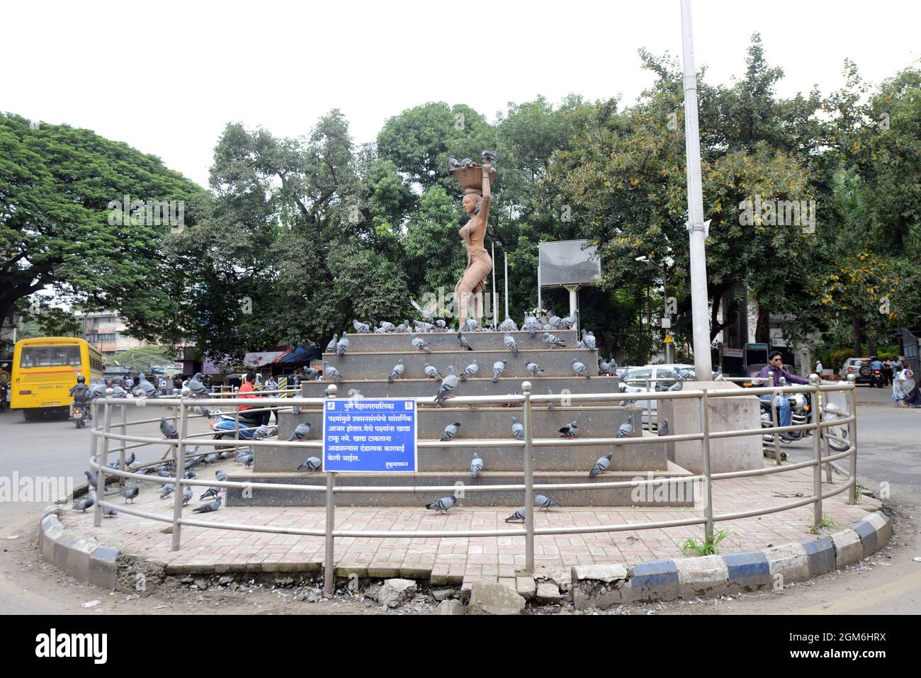 Eine Skulptur einer Frau, die in einem Kreisverkehr in Pune, Indien, einen Korb auf dem Kopf trägt. Stockfoto