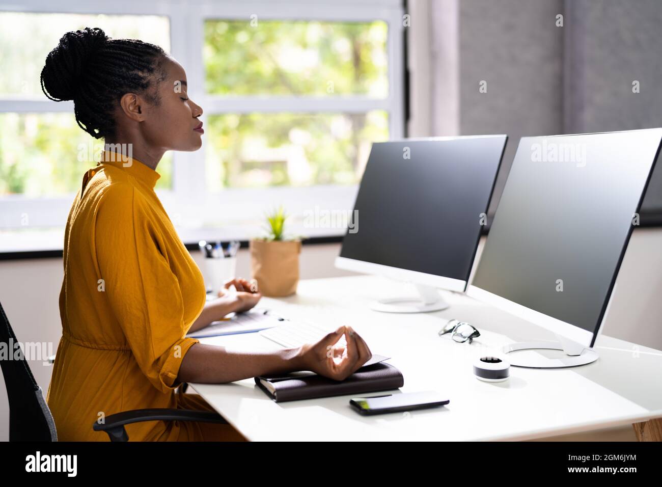 Afroamerikanische Frau Stress Management. Meditieren In Der Nähe Des Computers Stockfoto