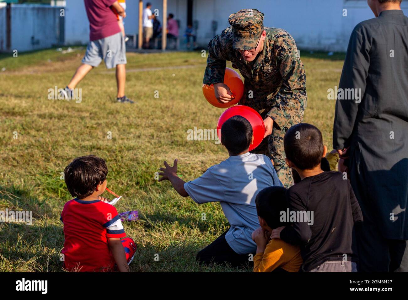 Theodore Marcus, ein Spezialist für religiöse Programme der 26. Marine Expeditionary Unit (MEU), interagiert während der Operation Allies Welcome in Fort Pickett, Virginia, am 15. September 2021 mit afghanischen Kindern. Das MEU-Kommandoelement und andere unterstützende Einheiten des 3. Bataillons, des 6. Marinegiments und der 2d-Marinedivision unterstützen die Operation Allies Herzlich Willkommen. Das Verteidigungsministerium stellt über das Northern Command der USA und zur Unterstützung des Heimatschutzministeriums Transport, vorübergehende Unterbringung, medizinische Vorsorgeuntersuchungen und allgemeine Unterstützung für bereit Stockfoto