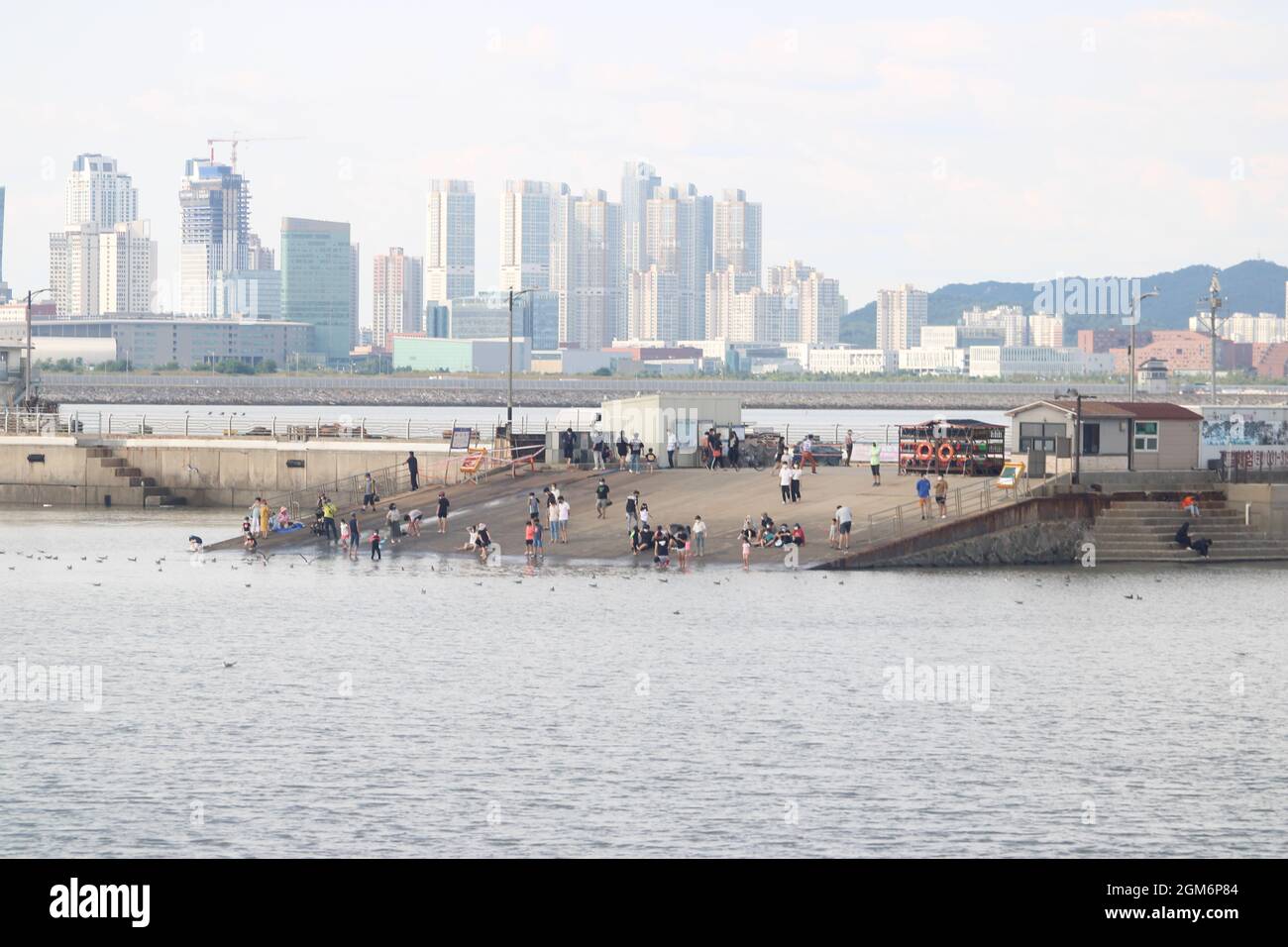 Fernansicht von Menschen, die sich am Strand der Bootsrampe versammeln, im Oido Marine Park, Oido, Korea Stockfoto