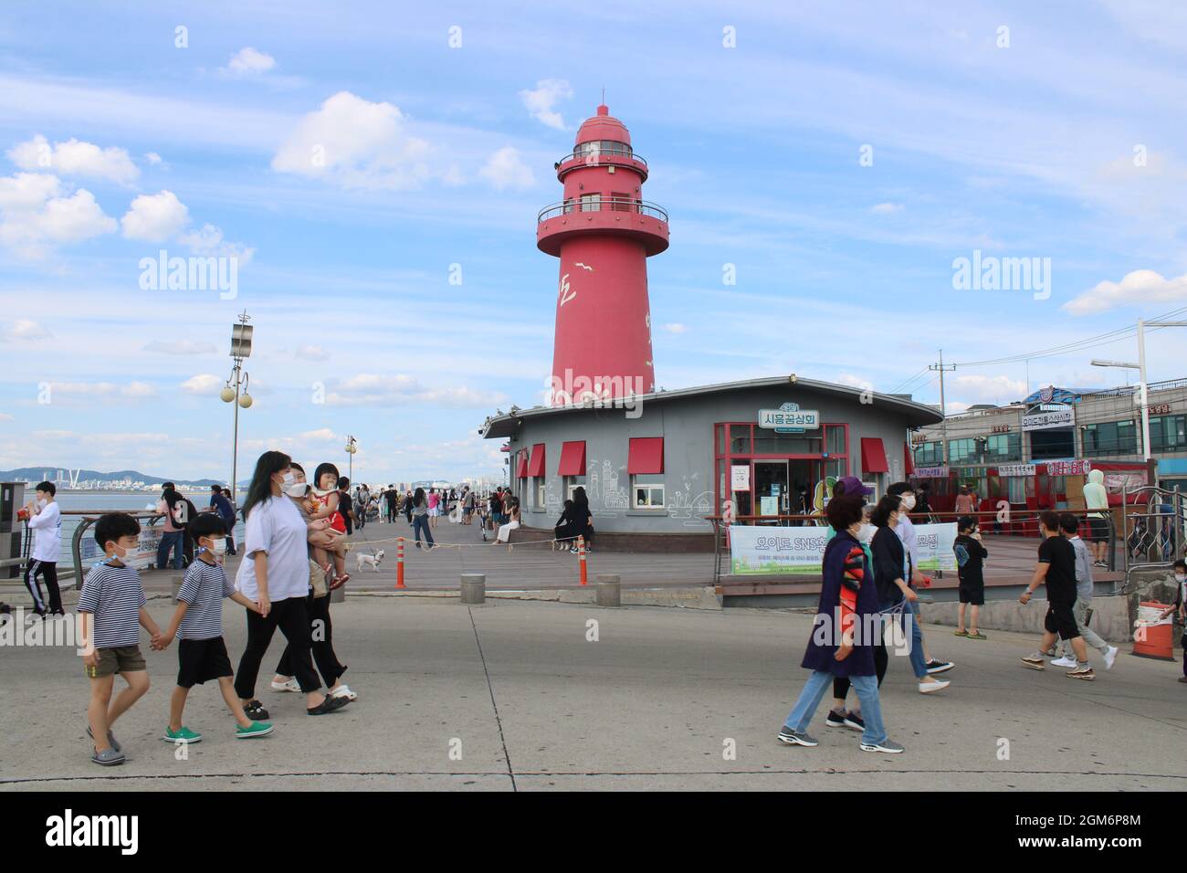 Menschen, die am berühmten Rotlichthaus im Oido Marine Park, Oido, Korea, vorbeilaufen Stockfoto