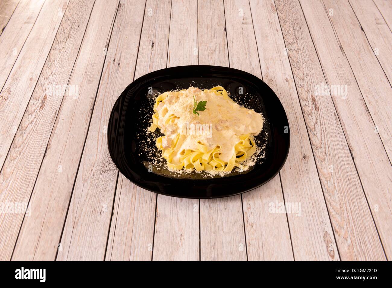 Tagliatelle mit frischer Pasta, mit Carbonara-Sauce mit Guanciale auf Holztisch Stockfoto