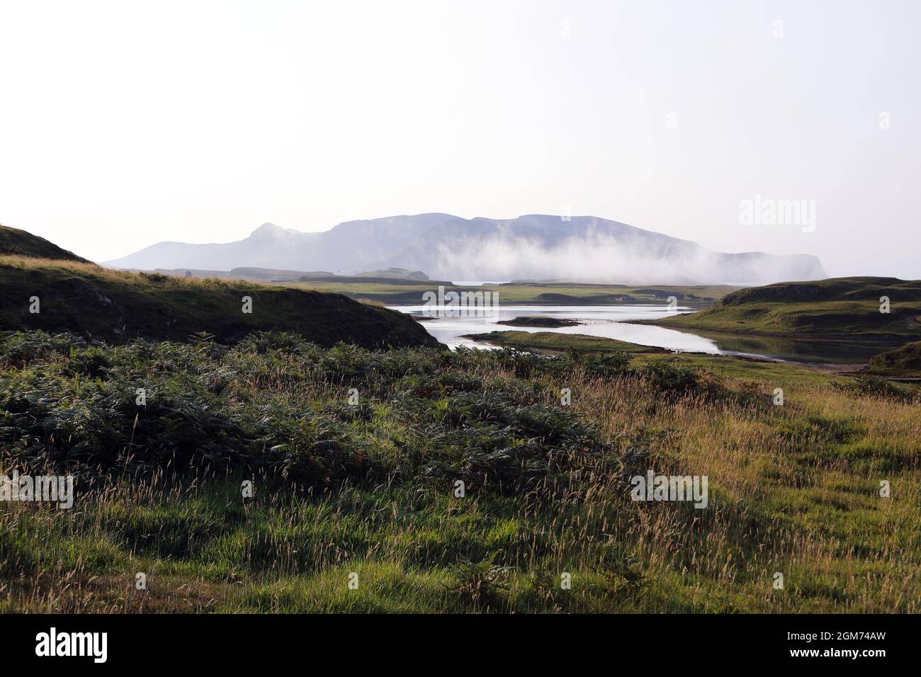 Meeresnebel rollt zwischen der Isle of Canna im Vordergrund und der Isle of Rum in der Ferne in den Inner Hebriden von Schottland Stockfoto