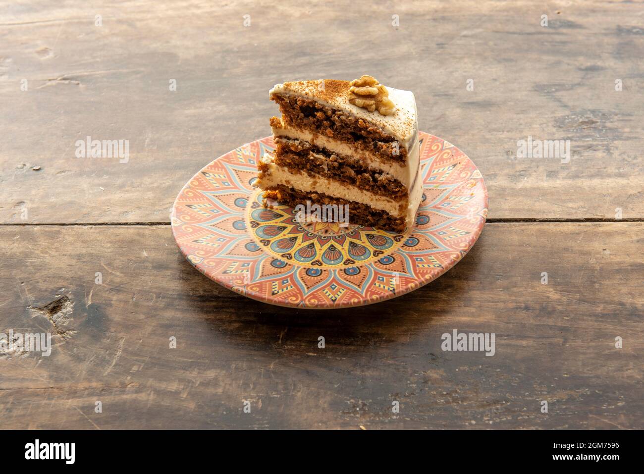 Dreistufiger Karottenkuchen auf buntem Teller Stockfoto