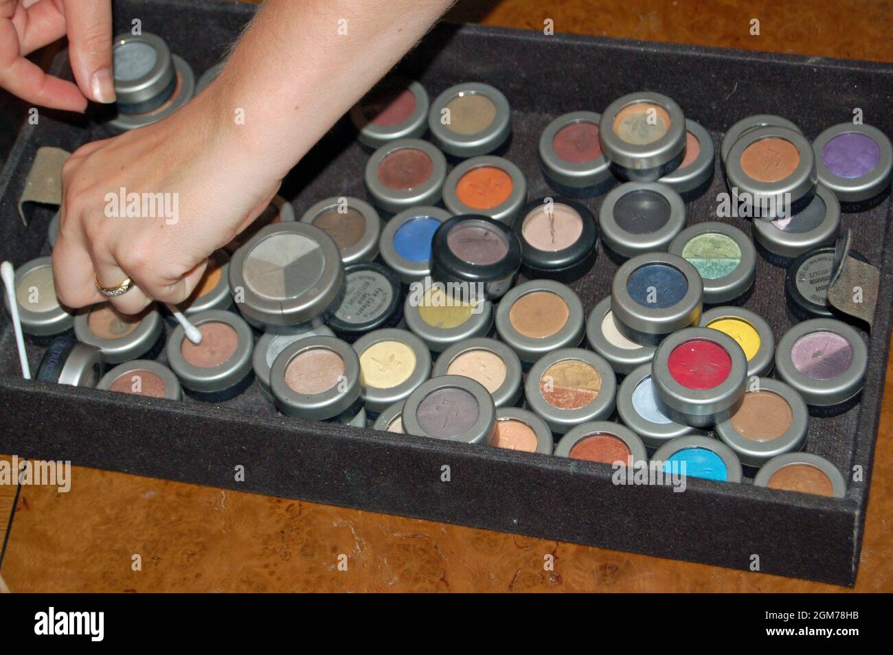 Lymington, Großbritannien - 1. Juli 2006: Ein Make-up-Künstler, der durch ein Tablett mit Pudertöpfen auf der Suche nach dem richtigen Farbschatten sucht. Stockfoto